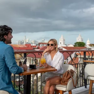 Pareja sentada alegre en una mesa de un bar desde un balcón en Casco Antiguo de Panamá