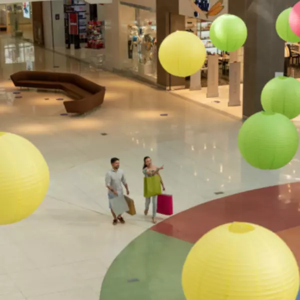 Vista aérea en el Shopping de Multiplaza con una pareja de turistas con bolsas de compras