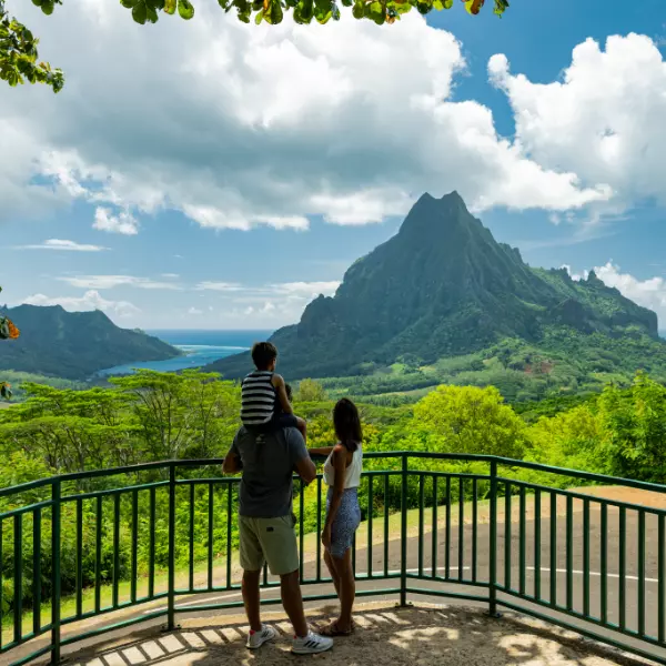 Pareja con su hijo mirando las montañas desde una terraza en Moorea Polinesia Francesa
