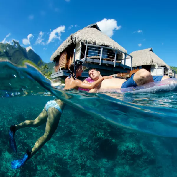 Persona haciendo snorkeling desde su cabaña sobre el mar en Polinesia Francesa